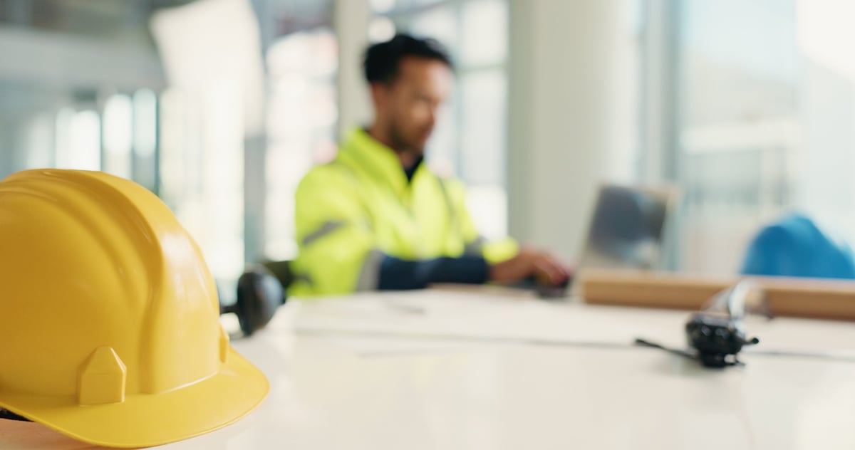 A maintenance professional inspecting a commercial property site with equipment
